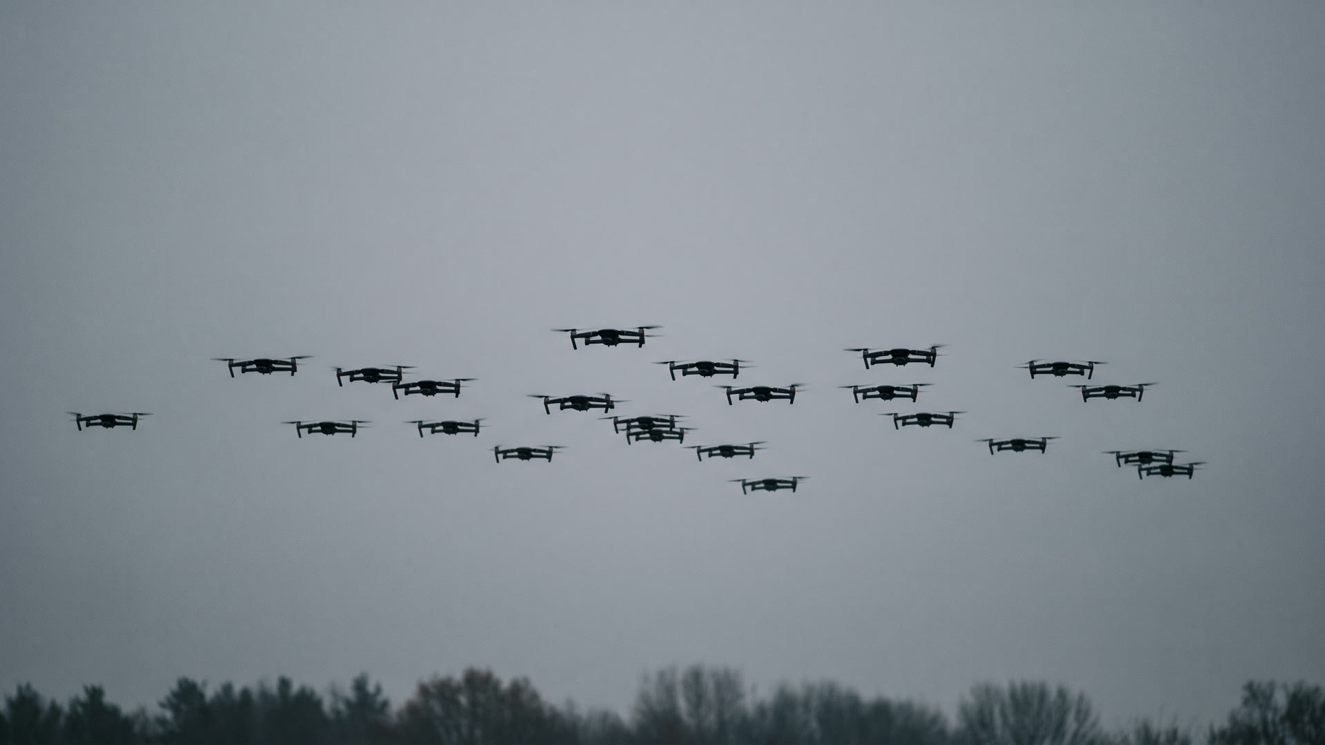A saturating raid of small unmanned aircraft under overcast — the target set KNELL is built against